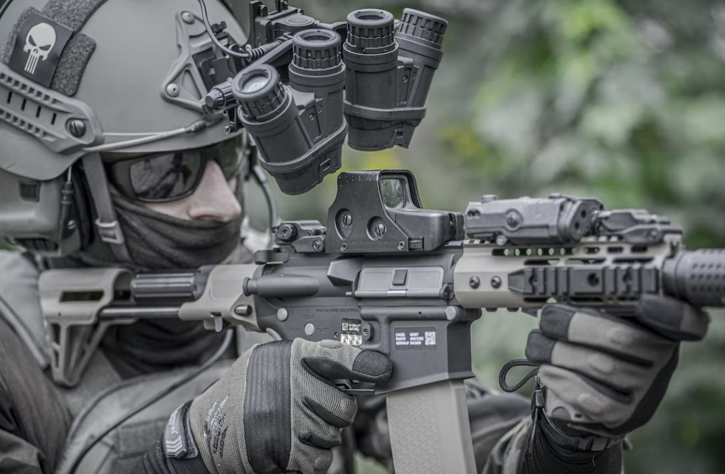 airsoft player with a peq15 laser sight mounted to airsoft rifle